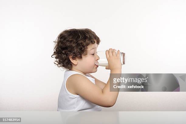 child drinking milk from a glass against a white background - boy drinking milk stock pictures, royalty-free photos & images