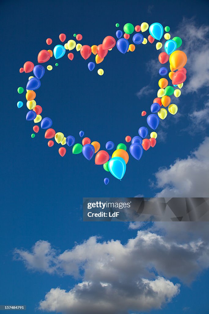 Cuore a forma di palloncini contro il cielo con nuvole