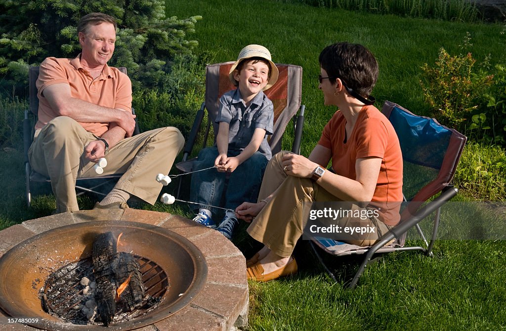 Family relaxing around fire pit