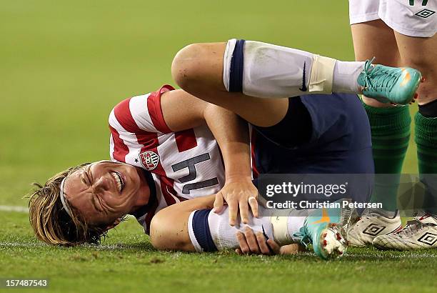 Abby Wambach of USA reacts in pain after a collisionf during the second half of the game at University of Phoenix Stadium on December 1, 2012 in...