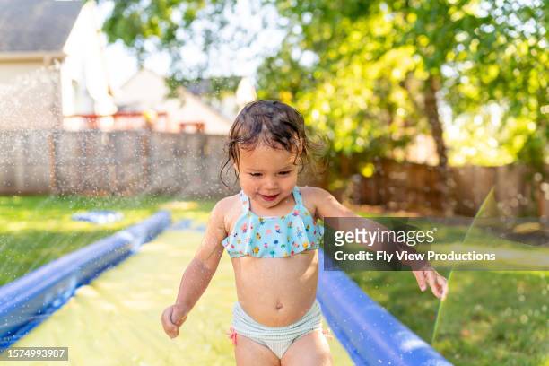 happy toddler girl playing in the backyard on a hot summer day - hot american girl stock pictures, royalty-free photos & images