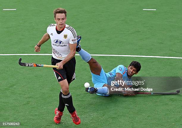 Birendra Lakra of India gets knocked down by Tom Meiling of Germany during the match between India and Germany during day three of the Champions...