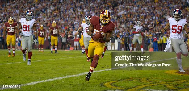 Washington's wide receiver Pierre Garcon lands in the endzone for a touchdown after catching a pass from Washington's quarterback Robert Griffin III...