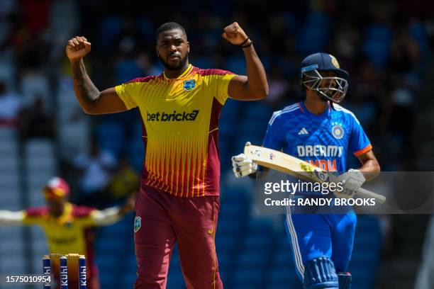 Obed McCoy of West Indies celebrates the dismissal of Axar Patel of India during the first T20I match between West Indies and India at Brian Lara...