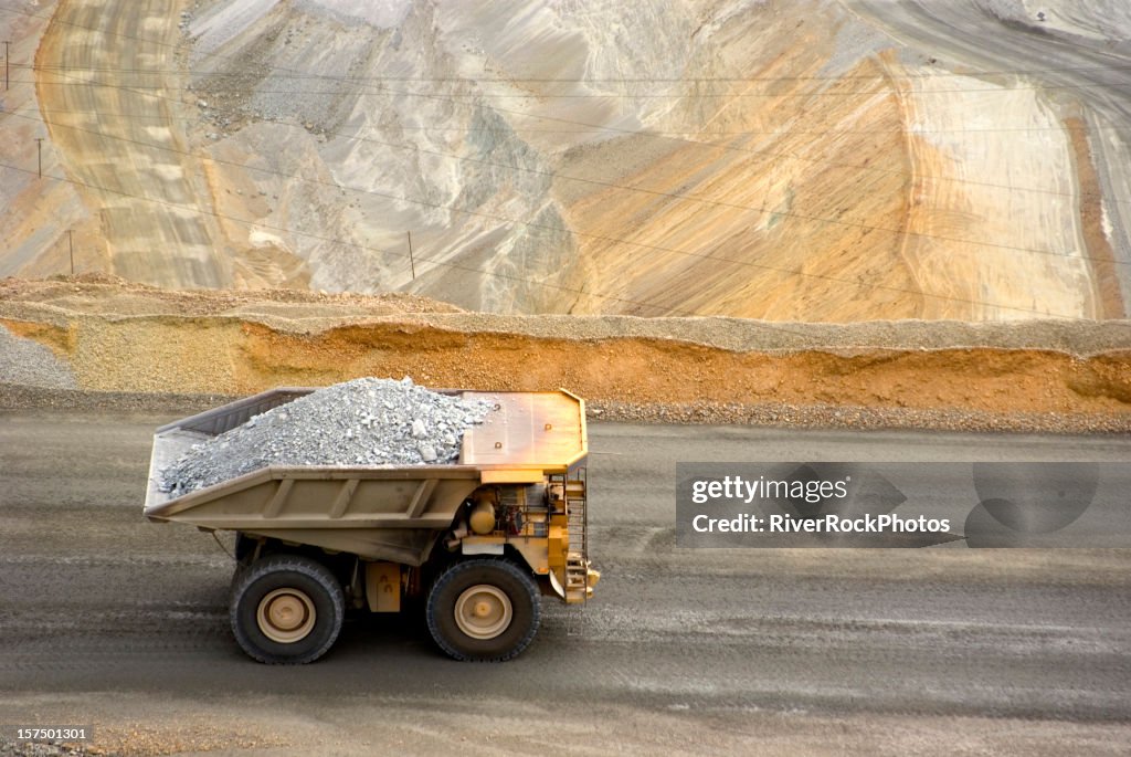 Yellow large dump truck in Utah copper mine seen from above