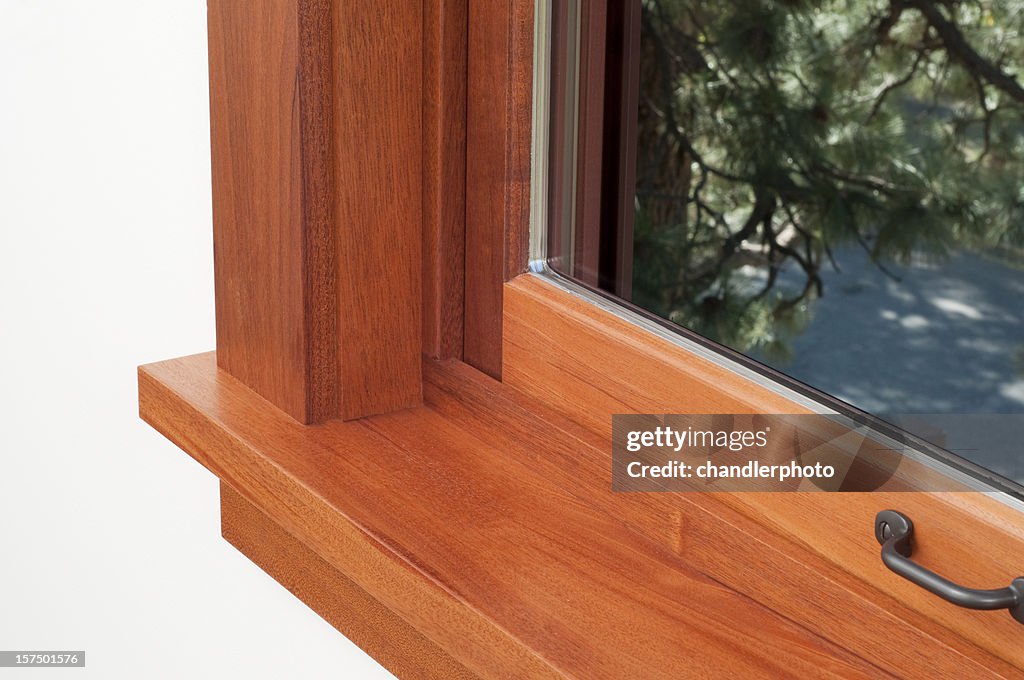 Corner of a window sill with a brown wooden frame