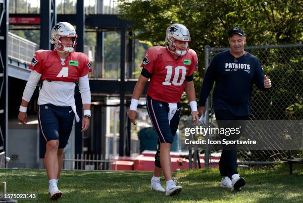 New England Patriots offensive coordinator / quarterbacks coach Bill O'Brien chats with quarterbacks Bailey Zappe and Mac Jones as they walk onto the...