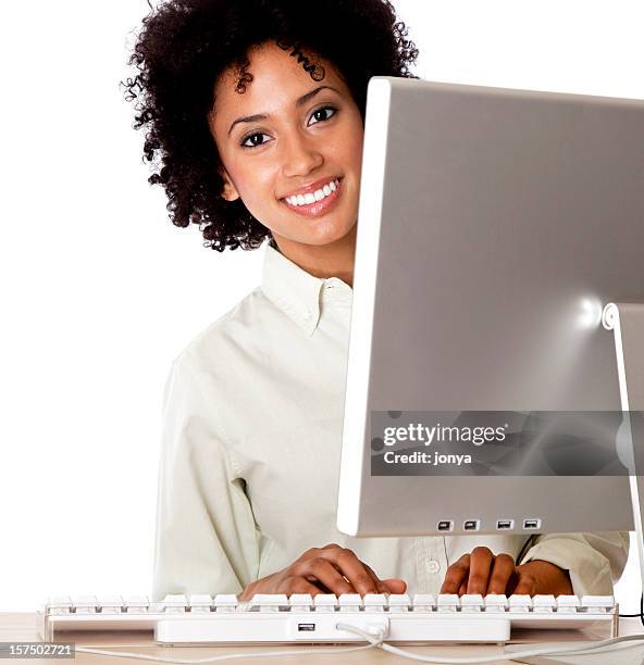 smiling young woman peeking behind computer monitor - man and machine stock pictures, royalty-free photos & images