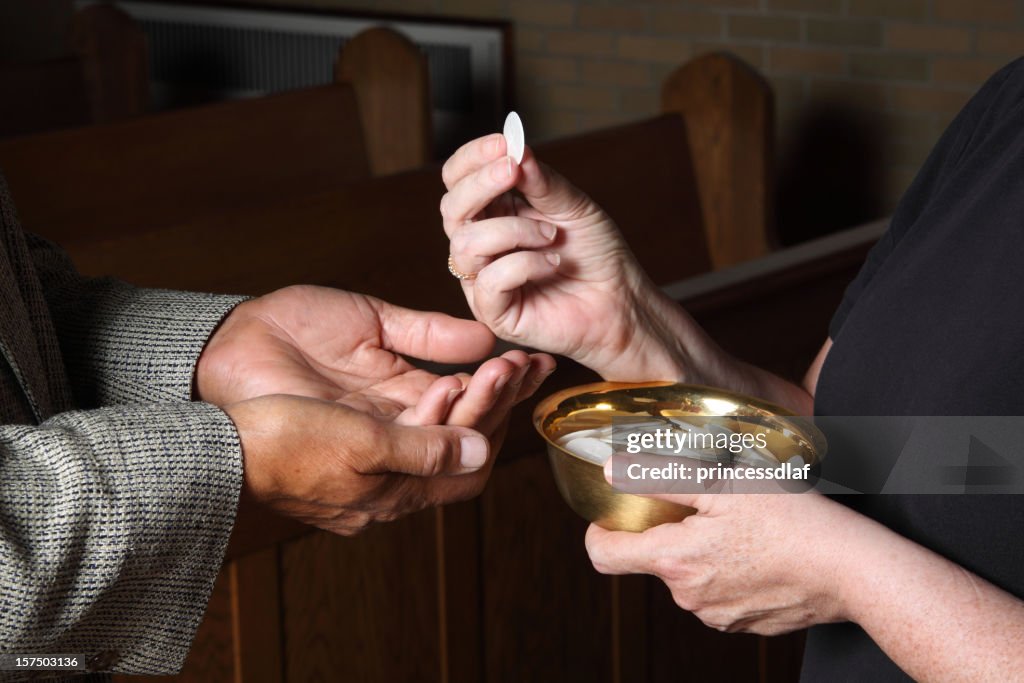 Close up of hands giving Communion