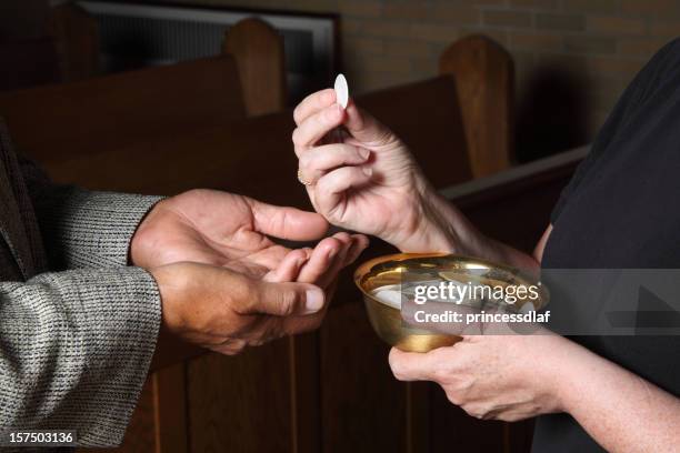 close up of hands giving communion - receiving-holy-communion stock pictures, royalty-free photos & images