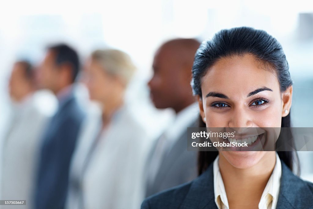 Businesswoman smiling with colleagues in the background