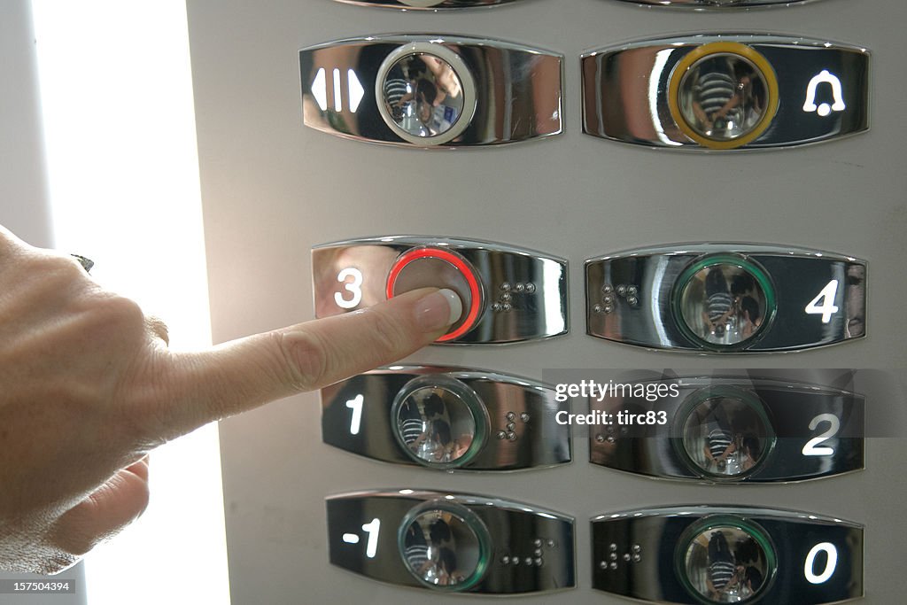 Woman's finger pressing elevator button