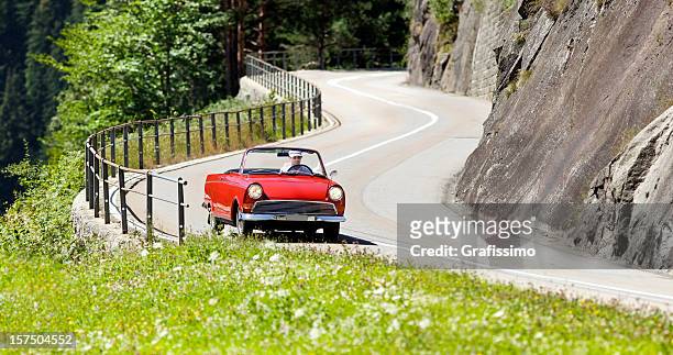antique red vintage car on alpine road - vintage car racing stock pictures, royalty-free photos & images