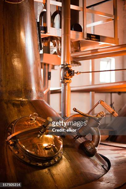 machines operating a whiskey distillery in islay, scotland  - scotch whisky stock pictures, royalty-free photos & images