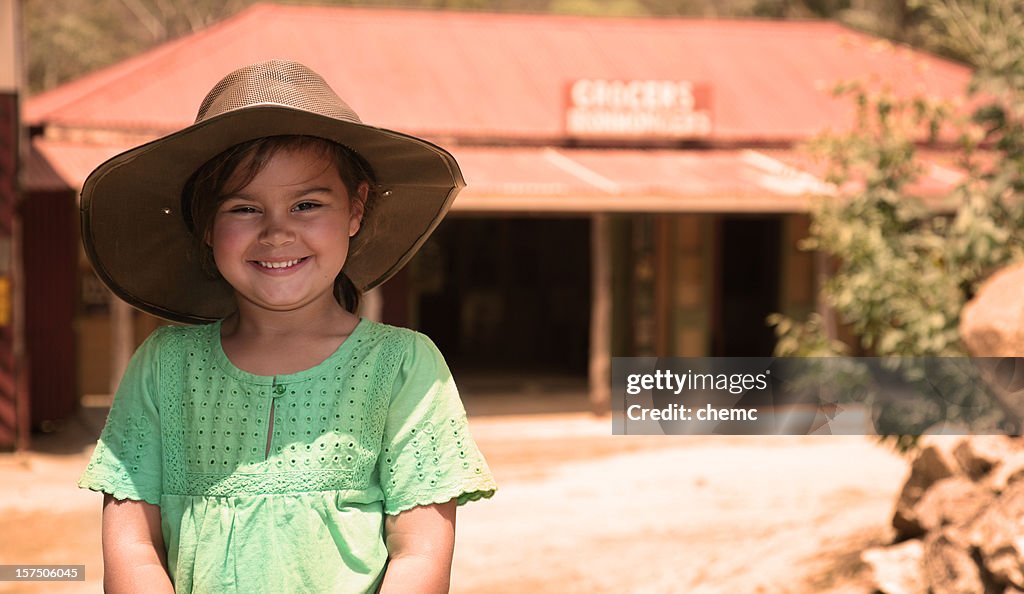 Smiling young girl wearing a hat in Australian Outback