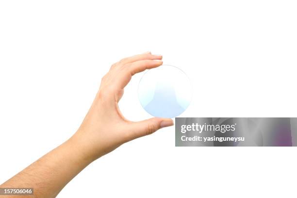 hand holding an eyeglass lens without the glasses on white - finger lens stock pictures, royalty-free photos & images