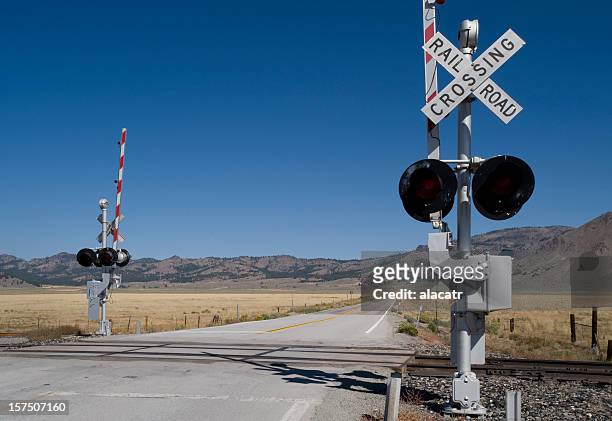 railway level crossing on both sides of extended road - nevada stock pictures, royalty-free photos & images