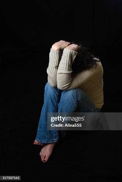 sad woman sitting down covering her face - crying fetal position stock pictures, royalty-free photos & images