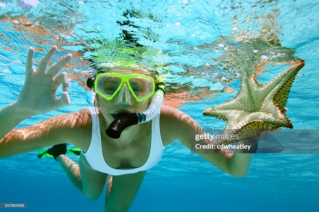 Woman snorkeling with a starfish