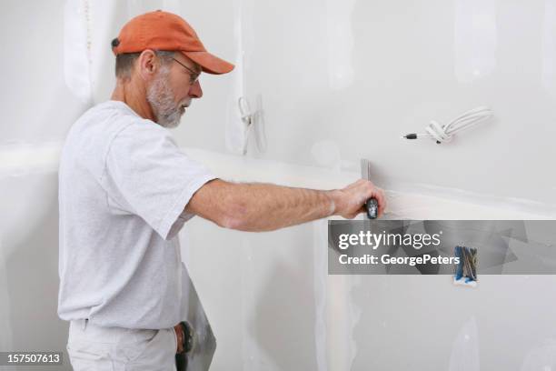 applying mud to sheetrock - drywall stock pictures, royalty-free photos & images