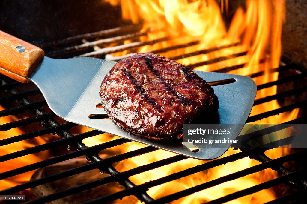Hamburger di manzo Patty su Grill con fuoco