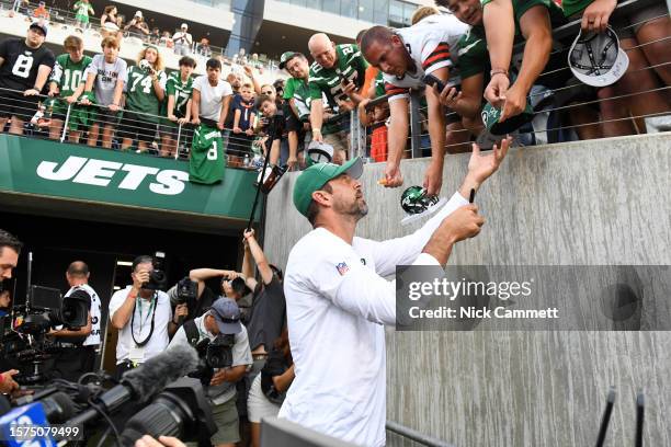 Aaron Rodgers of the New York Jets signs autographs prior to the 2023 Pro Hall of Fame Game against the Cleveland Browns at Tom Benson Hall Of Fame...