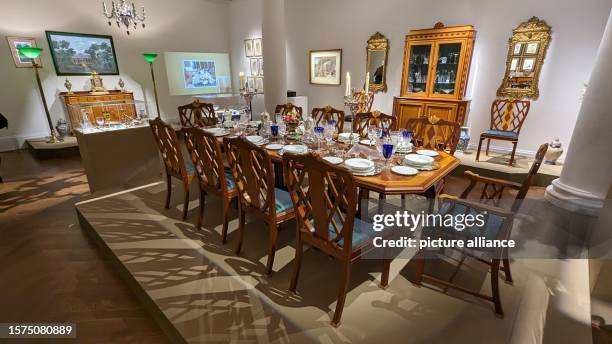 August 2023, Great Britain, London: Dining table with tableware and furnishings from the estate of British rock singer Freddie Mercury. The...