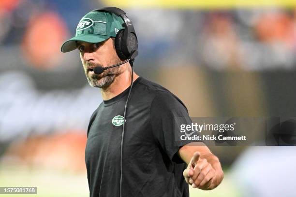 Aaron Rodgers of the New York Jets looks on during a delay in the second half of the 2023 Pro Hall of Fame Game against the Cleveland Browns at Tom...