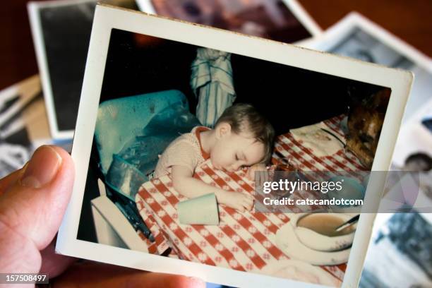 hand holds vintage photograph of boy at thanksgiving - passed out drunk stockfoto's en -beelden