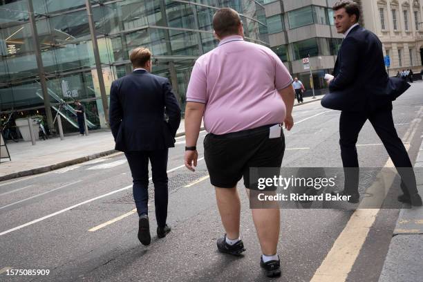 Three men cross the road in the City of London, the capital's financial district, on 1st August 2023, in London, England.