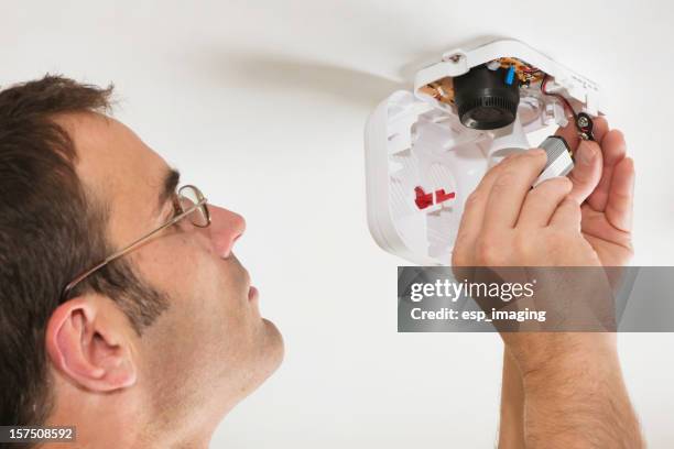 changing the battery in a fire alarm - sirene stockfoto's en -beelden