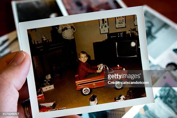 hand holds vintage photograph of boy in pedal car - vintage car bildbanksfoton och bilder