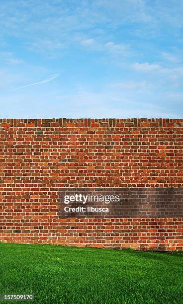 rote wand mit grünem gras und himmel - red sky stock-fotos und bilder