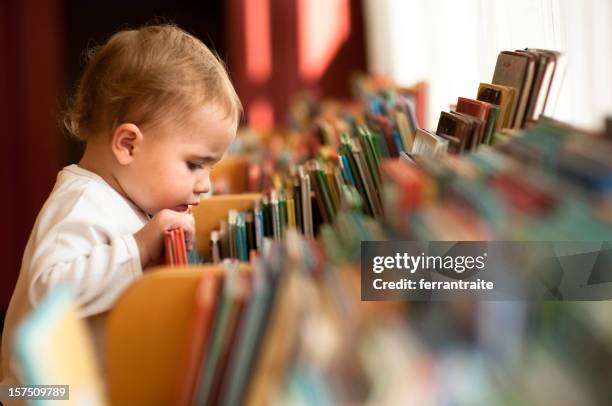 little girl in library - book library stock pictures, royalty-free photos & images