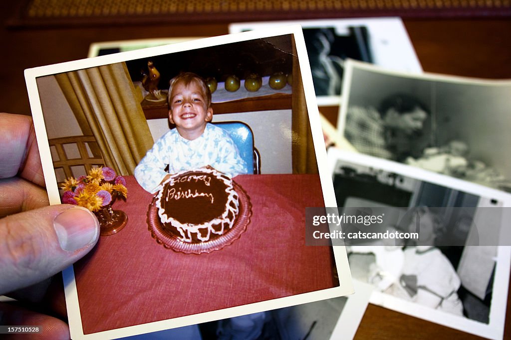 Mano tiene fotografia Vintage di un bambino e torta di compleanno