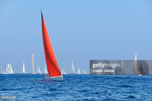 boat with a red sail during the sailin competition - regatta stockfoto's en -beelden