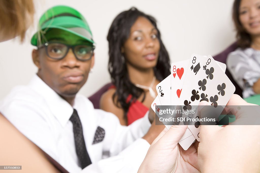 Poker-Spieler hält ein volles Haus mit anderen Spielern vor