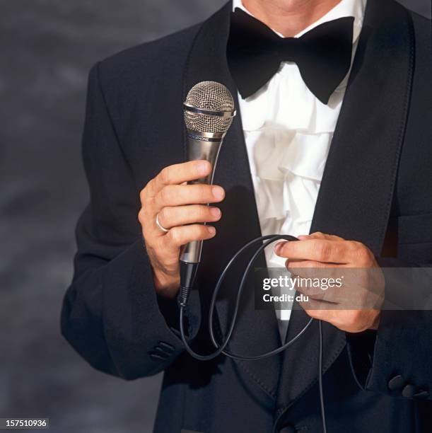 conferencier in elegant suit holding the microphone - compere stock pictures, royalty-free photos & images