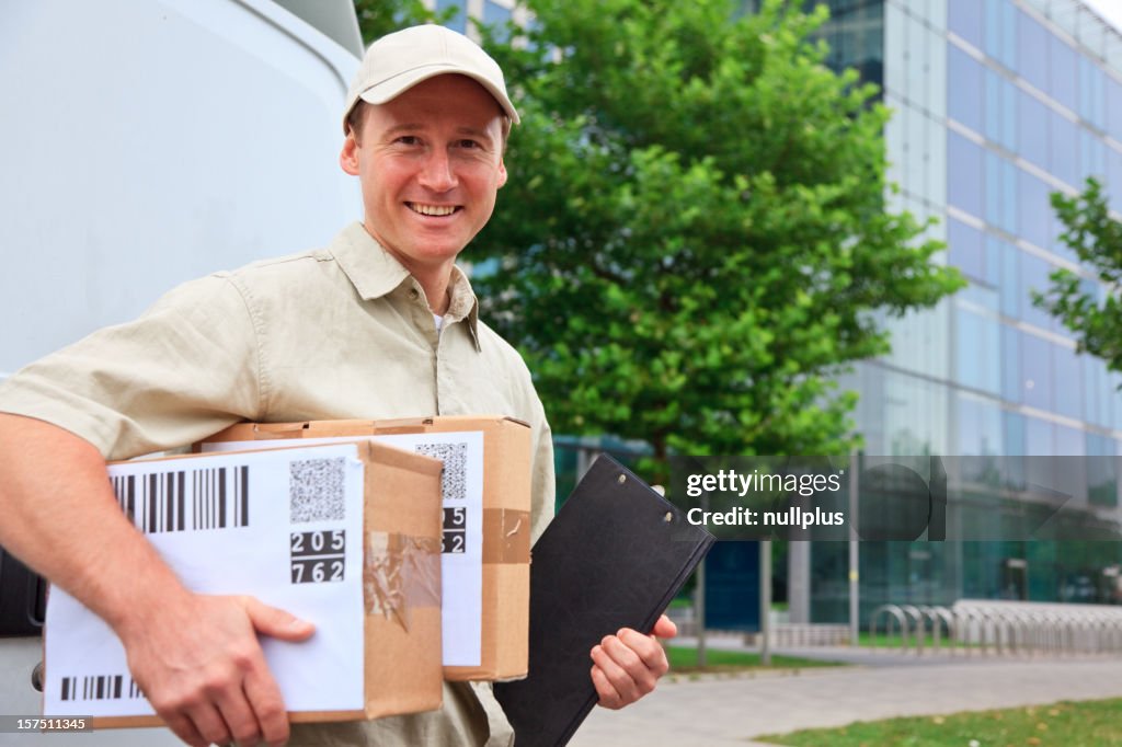 Delivery boy standing next to his van