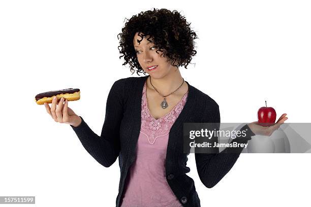 woman weighing healthy eating choices;diet cravings apple vs donut - james hale stock pictures, royalty-free photos & images