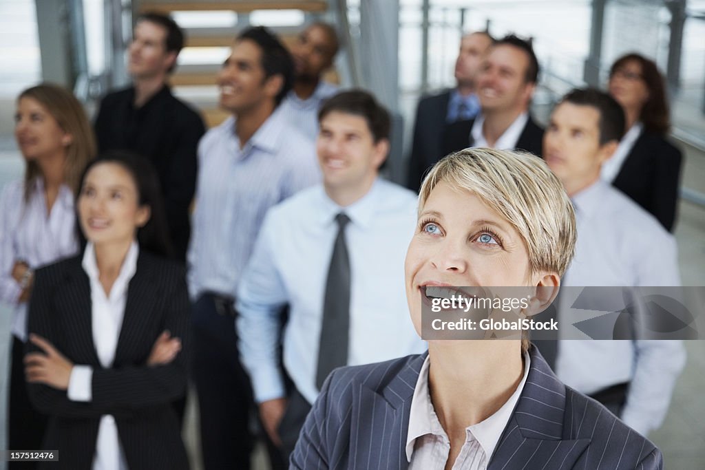 Businesswoman looking away with colleagues in the background