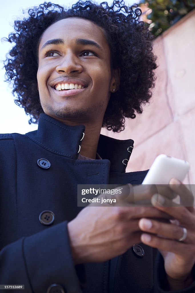 Sorridente jovem Homem negro enviar mensagens de texto
