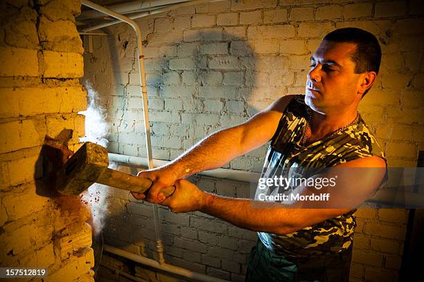 brutal construction worker destroying brick wall with sledgehammer - sledge hammer stock pictures, royalty-free photos & images