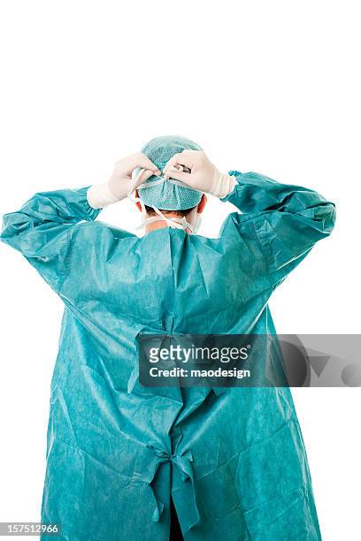a male surgeon securing his mask to his head - doctor behind stock pictures, royalty-free photos & images