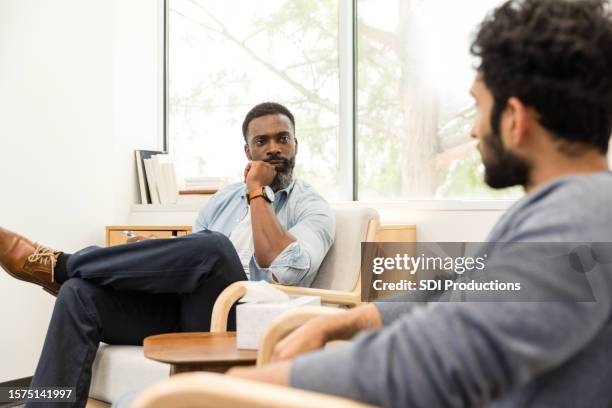 male counselor seriously evaluates what male patient is sharing - bounce back stock pictures, royalty-free photos & images