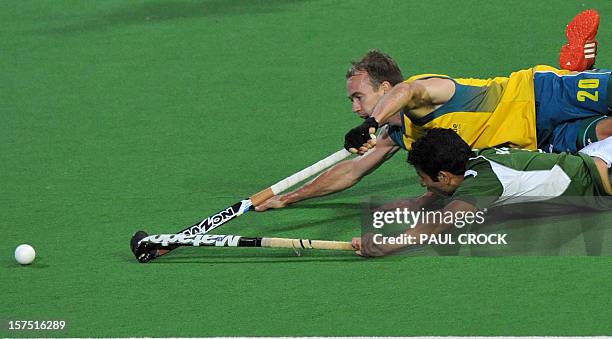 Matthew Swann of Australia slides over Muhammad Rizwan Jnr of Pakistan during their Pool B match at the Men's Hockey Champions Trophy tournament in...