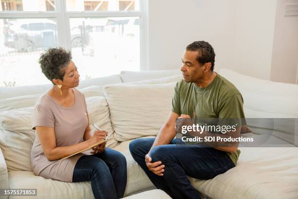 mature male veteran gestures while talking to his therapist - project heal stockfoto's en -beelden