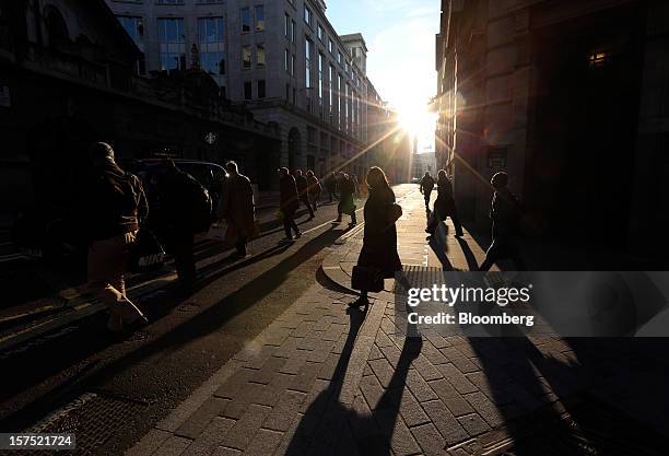 Pedestrians cross an intersection in the financial district in London, U.K., on Friday, Nov. 30, 2012. U.K. Banks have become more unwilling to...