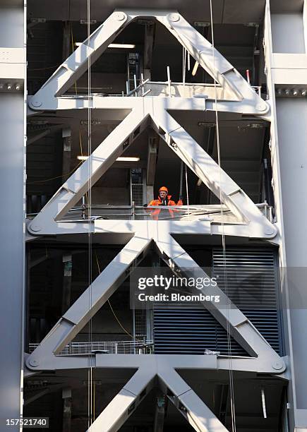 Worker stands amongst the metal structure of the Leadenhall building during construction in London, U.K., on Friday, Nov. 30, 2012. U.K. Banks have...