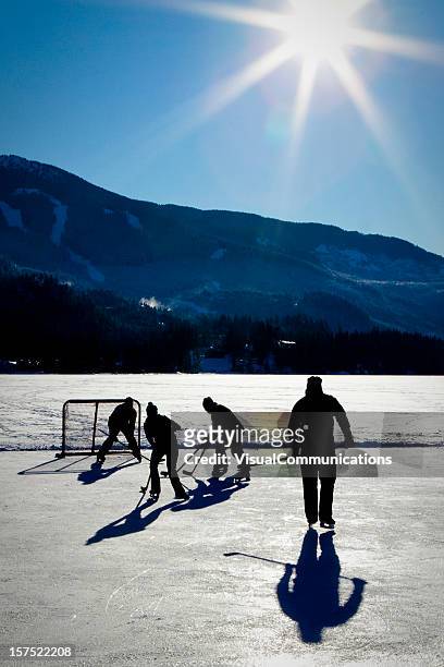 spielt eishockey auf zugefrorenen see. - pond hockey stock-fotos und bilder